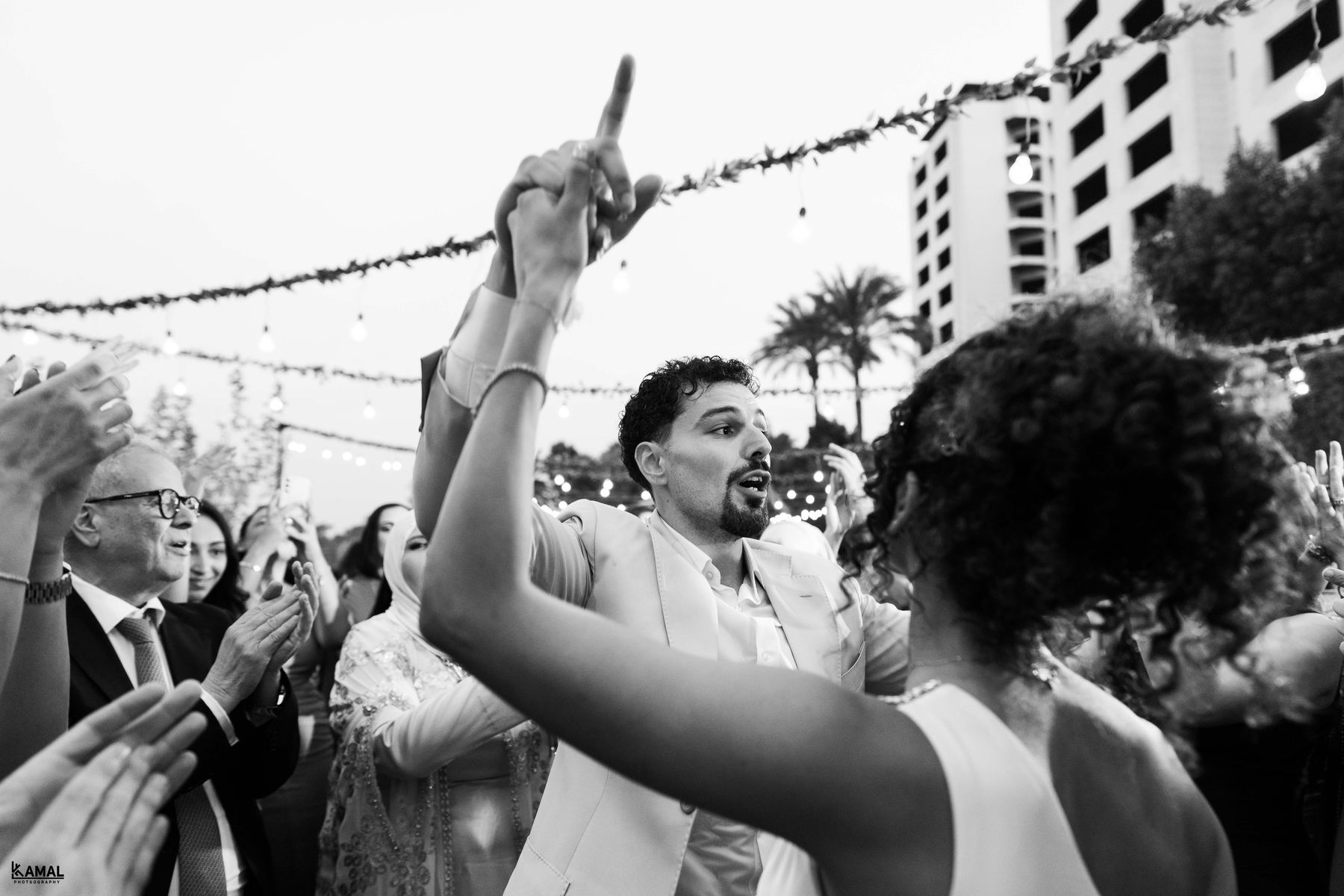Dancing under string lights, in black and white