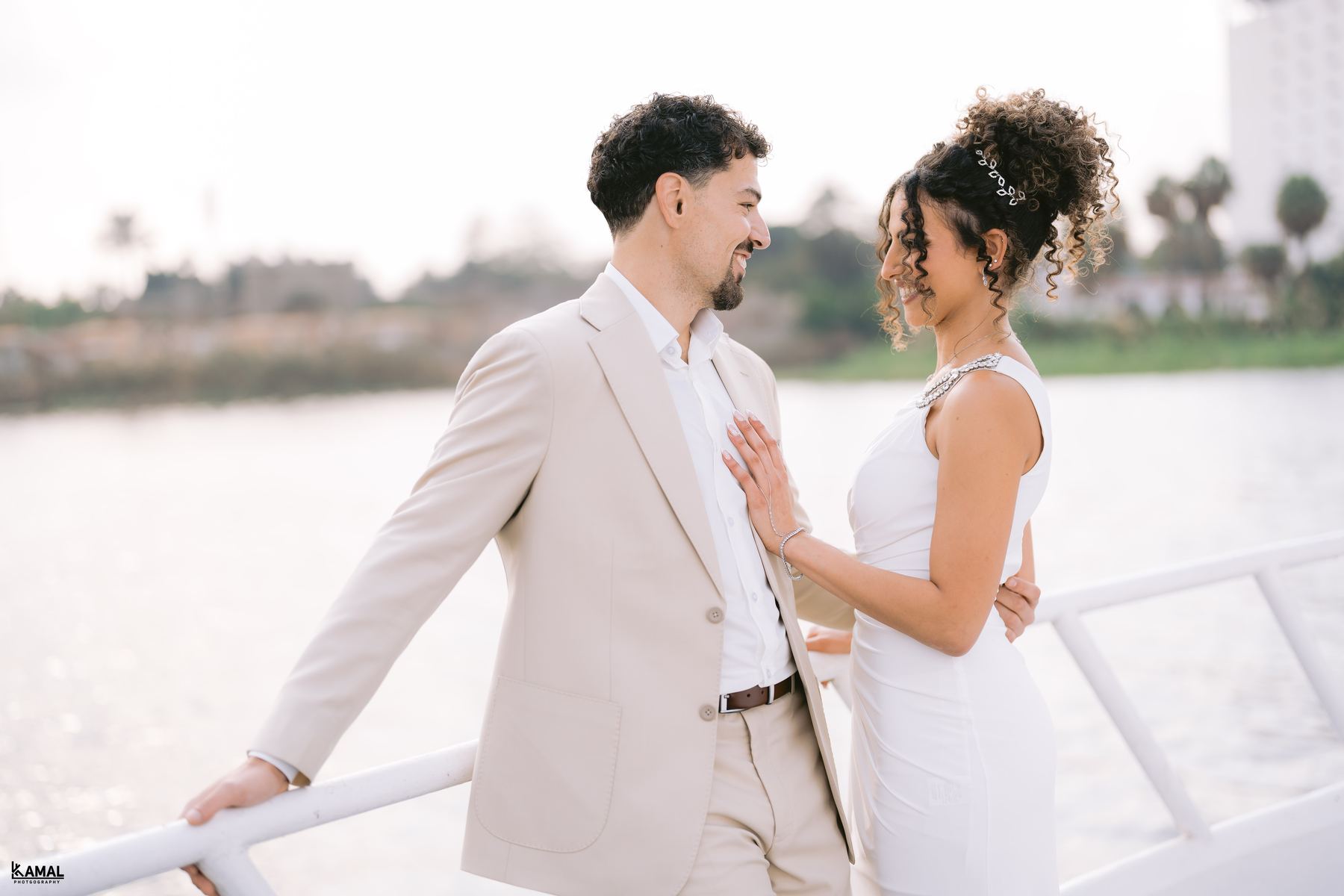 Anas and Salma facing each other on the deck, the Nile behind them