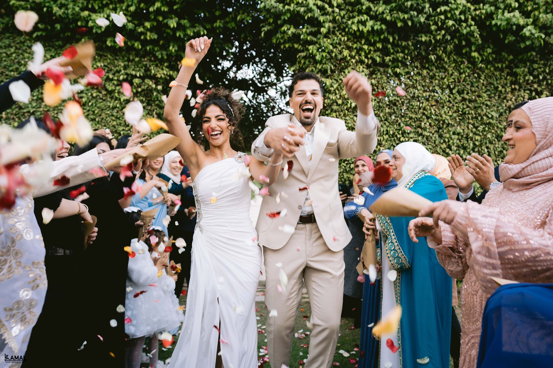 Walking out through a shower of rose petals thrown by family and friends